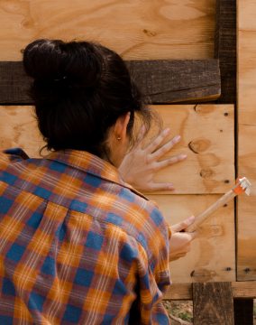 femme qui tape avec un marteau sur un clou